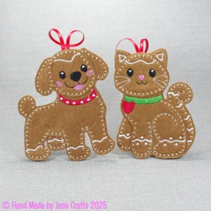 May include: Two felt ornaments: a dog and a cat. The dog is brown with a red collar and a red ribbon. The cat is brown with a green collar and a red heart. Both have white stitching and red ribbons for hanging. Text: Hand Made by Jane Crafts 2025.