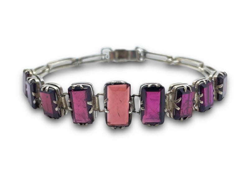 May include: A silver bracelet with a chain link design and rectangular pink and purple gemstones.