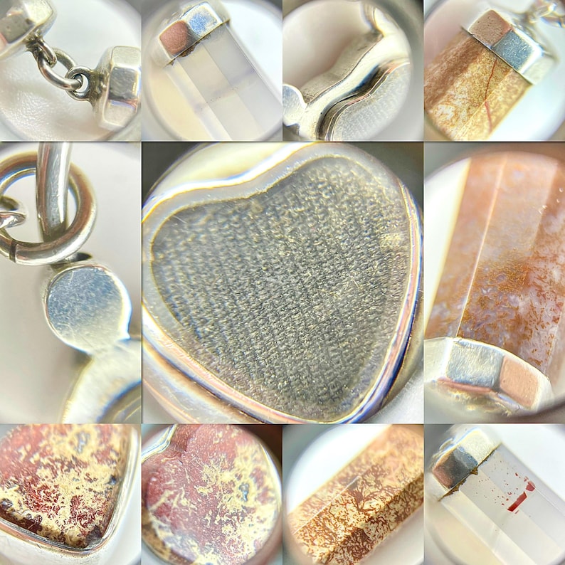 May include: Close-up of various silver pendants and charms with different gemstone and crystal designs. The gemstones include clear, brown, and red-toned stones, some with unique patterns. The silver settings have a polished finish.