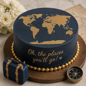Könnte beinhalten: Ein runder Kuchen mit dunkelblauem Zuckerguss, einer goldenen Weltkarte auf der Oberseite und dem Text "Oh, the places you'll go!" mit einem Herz an der Seite. Der Boden ist mit goldenen Kugeln verziert, dazu ein kleiner blauer Koffer und ein Kompass.