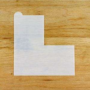 Può includere: Uno stencil a forma di L in plastica bianca per la cottura e la decorazione di torte.