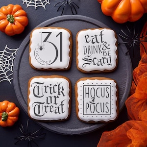 May include: Four square Halloween cookies with white icing and black text. The cookies are decorated with the phrases "31 October", "Eat Drink & Be Scary", "Trick or Treat", and "Hocus Pocus". The cookies are on a gray plate with pumpkins and spider decorations.