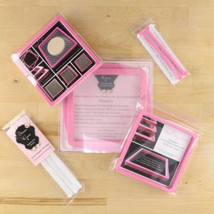 Peut inclure: Pochoirs en plastique rose pour l'artisanat, comprenant un cadre carré, un cadre carré plus petit et un cadre circulaire. Les pochoirs sont emballés dans des sacs en plastique transparents. L'image comprend également un ensemble d'instructions pour l'utilisation des pochoirs.