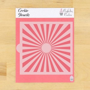 May include: Pink plastic cookie stencil with a sunburst design. The stencil is for decorating cookies and cakes.