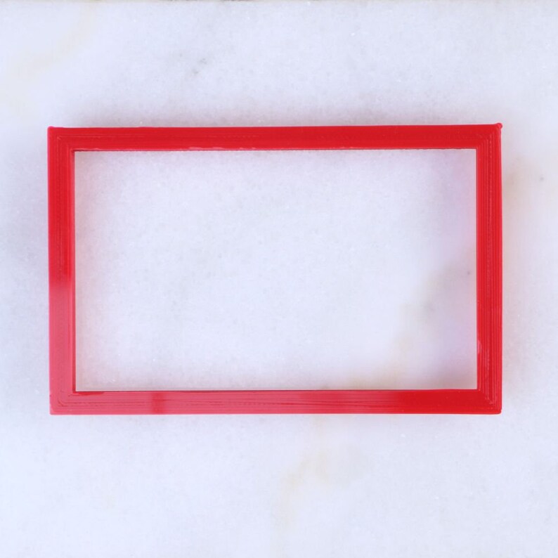 May include: A red plastic frame on a white background.