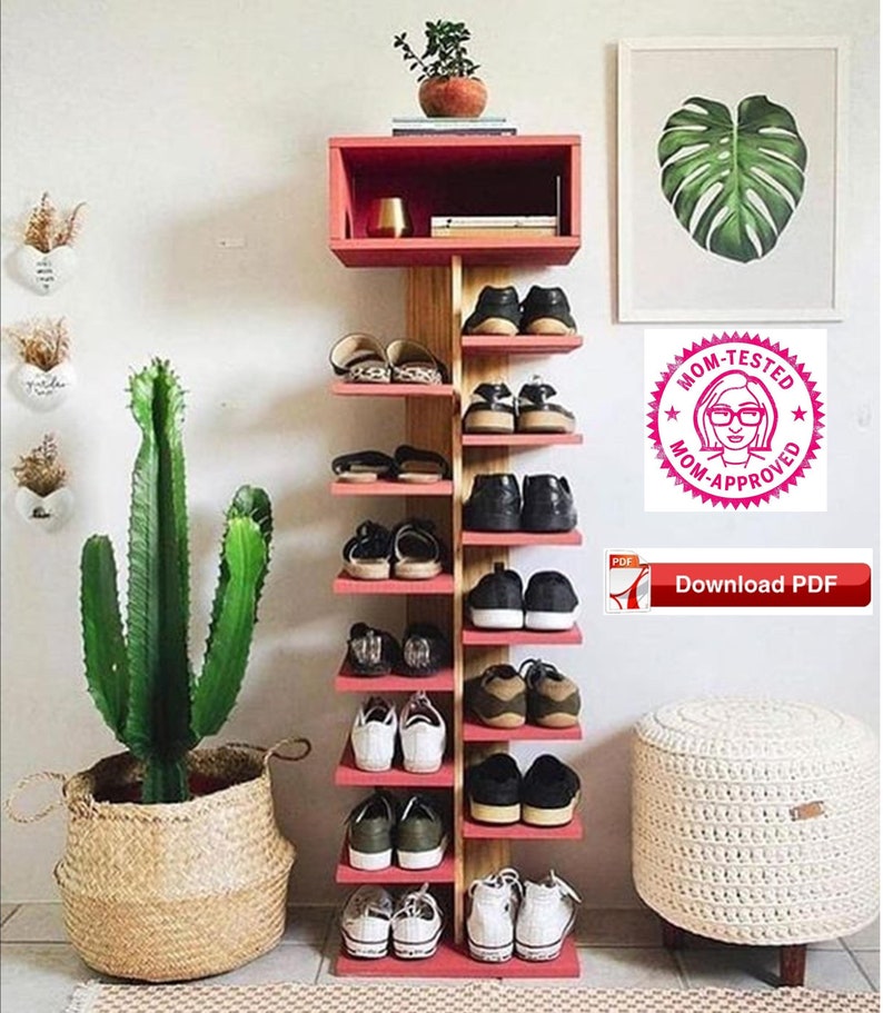 May include: A red and wood shoe rack with 8 shelves, holding a variety of shoes. The rack is in a room with a cactus plant in a wicker basket, a white stool, and a framed print of a monstera leaf.