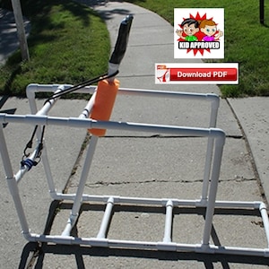 May include: A white PVC pipe frame with a black handle and orange float. The frame is designed for a water slide and has a blue bungee cord attached to it. The image includes the text "KID APPROVED" and "Download PDF".