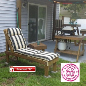 Könnte beinhalten: Ein Holz-Liegestuhl mit einem schwarz-weiß gestreiften Kissen. Der Stuhl steht auf einer Terrasse mit einem Grill und einem Tisch. Der Text "Mom-Tested Mom-Approved" befindet sich auf einem rosa runden Aufkleber.