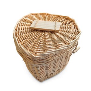 May include: A heart-shaped woven wicker basket with a matching lid. The basket features a light tan natural finish and a rectangular wooden plaque attached to the center of the lid with thin twine. The weave is tight and consistent throughout.