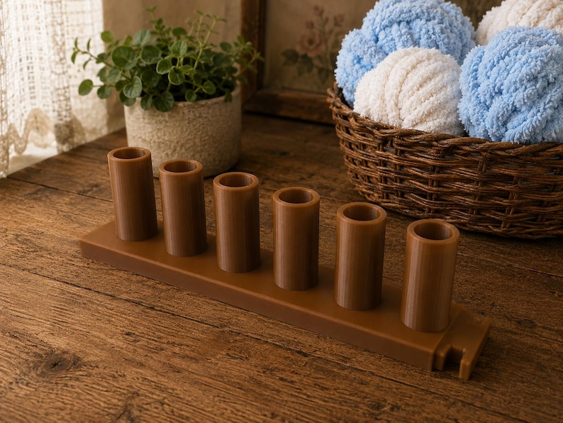 May include: A brown plastic organizer stand featuring six vertical cylindrical holders arranged in a single row on a rectangular base, with a small notched cutout on the right side of the base for additional storage or cable management.