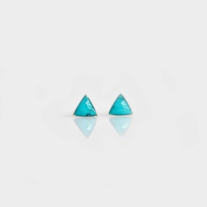 May include: A pair of silver triangle earrings with turquoise stones.
