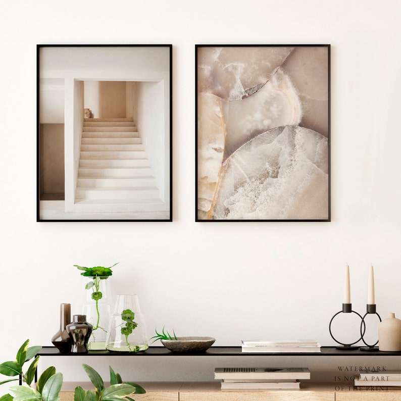 Puede incluir: Dos impresiones art&iacute;sticas enmarcadas. Una presenta una escalera en un entorno arquitect&oacute;nico en tonos beige. La otra muestra un primer plano de una geoda con tonos beige, blanco y gris. Ambas est&aacute;n en marcos negros, adecuadas para la decoraci&oacute;n del hogar.