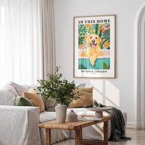 May include: A framed print with a yellow Labrador Retriever sitting in a pool of water surrounded by tropical plants. The text "In this home we speak Labrador" is printed below the image.