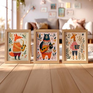 May include: Three framed prints in light wood frames featuring illustrations of animals playing musical instruments. The left print shows a fox with a saxophone, the center a bear with a guitar, and the right a giraffe with an accordion.