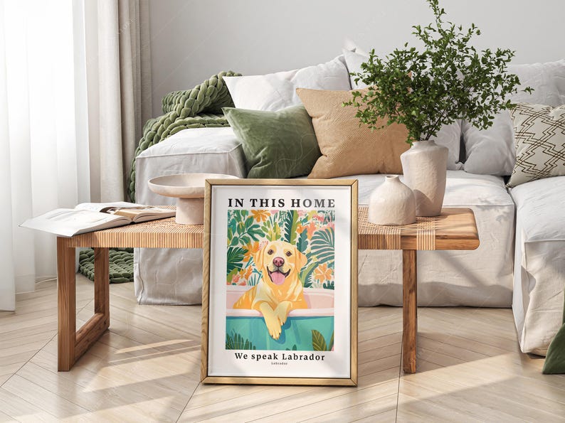 May include: A framed print with a yellow Labrador Retriever sitting in a bathtub surrounded by tropical plants. The text on the print reads "In this home we speak Labrador".