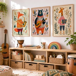 May include: Three framed wall art prints featuring a fox playing a saxophone, a bear playing a guitar, and a giraffe playing an accordion, all surrounded by botanical illustrations in warm tones, displayed above a wooden toy storage unit.
