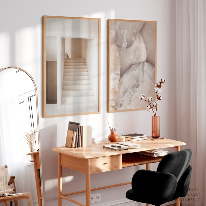 Puede incluir: Dos impresiones art&iacute;sticas enmarcadas. Una presenta una escalera en tonos neutros, la otra un primer plano de una formaci&oacute;n rocosa. Las impresiones cuelgan sobre un escritorio de madera con una silla negra, un espejo y objetos decorativos.