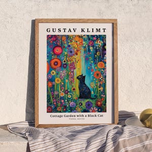 Pu&ograve; includere: Una stampa d'arte incorniciata che raffigura un gatto nero seduto in un giardino vivace e colorato pieno di fiori vari. Il testo in alto recita GUSTAV KLIMT e il testo in basso recita Cottage Garden with a Black Cat, Vienna, Austria.