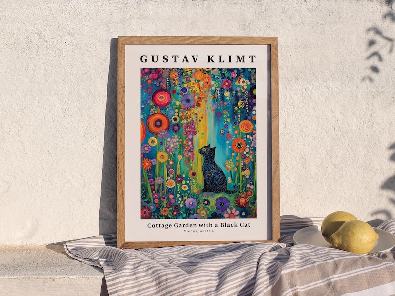 Pu&ograve; includere: Una stampa d'arte incorniciata che raffigura un gatto nero seduto in un giardino vivace e colorato pieno di fiori vari. Il testo in alto recita GUSTAV KLIMT e il testo in basso recita Cottage Garden with a Black Cat, Vienna, Austria.