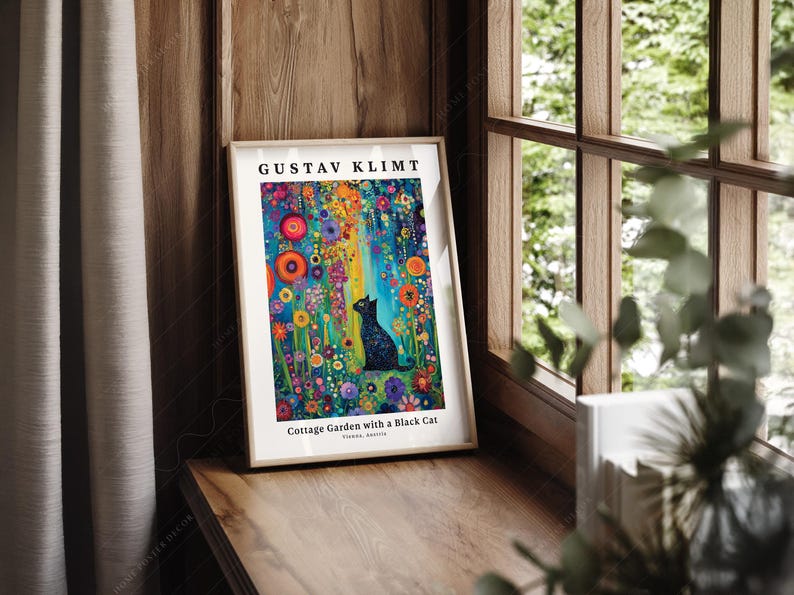 Pu&ograve; includere: Una stampa artistica incorniciata intitolata Gustav Klimt Cottage Garden with a Black Cat. L'immagine raffigura un gatto nero seduto in un giardino vivace pieno di fiori colorati nelle tonalit&agrave; del rosso, arancione, blu e viola su sfondo verde.
