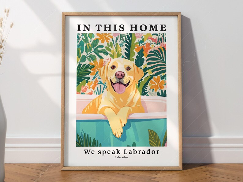 May include: A framed print with a yellow Labrador Retriever sitting in a bathtub surrounded by tropical plants. The text "In this home we speak Labrador" is printed below the image.