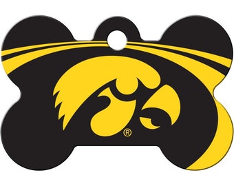 May include: Black and gold bone-shaped dog tag with the University of Iowa Hawkeye logo. The logo is a yellow hawk head with a black eye.