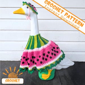 May include: A white goose figurine wearing a crocheted watermelon-themed outfit consisting of a green and pink dress with black seed details and a matching bonnet with pink ties. Text reads CROCHET PATTERN Instant Download and CROCHET IN THE SUNSHINE.
