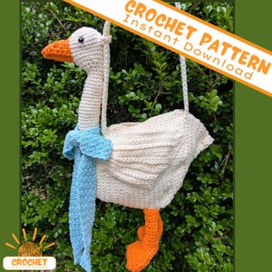 Pode incluir: Bolsa de ganso de crochê, com corpo branco, bico e pés laranja e um cachecol azul claro. A bolsa tem um pescoço longo e uma cabeça com um olho preto. O texto "CROCHET PATTERN Instant Download" está no canto superior direito.