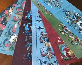 May include: A collection of decorative fabric pieces with ornate floral and scroll designs. The color palette includes shades of blue, red, green, and brown. The patterns are hand-painted with intricate details, showcasing a vintage aesthetic.