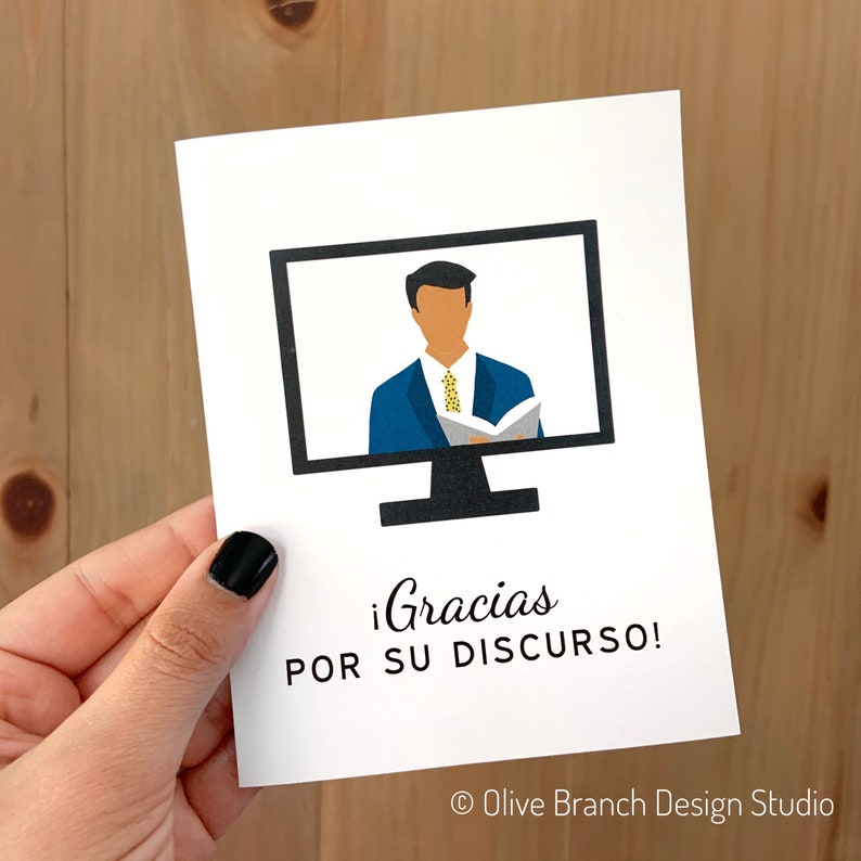 May include: A white card with a black computer monitor on it. The monitor shows a person in a blue suit and yellow tie giving a presentation. The text on the card says "&iexcl;Gracias por su discurso!" and "&copy; Olive Branch Design Studio".
