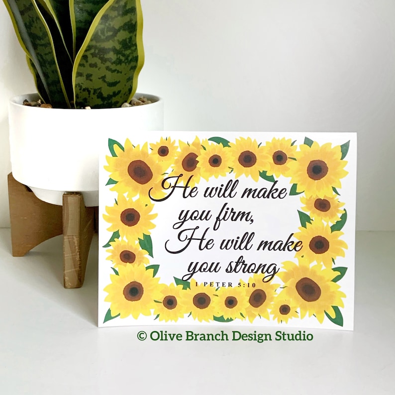 May include: A white card with a sunflower border and the text "He will make you firm, He will make you strong. 1 Peter 5:10" in black. The card also has the text "Olive Branch Design Studio" in the bottom right corner.