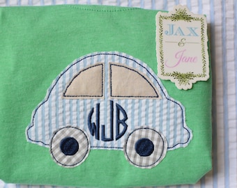 Puede incluir: Una camiseta verde con una aplicación de coche a rayas azules y blancas. El coche tiene un monograma "WJB" en el lateral y el texto "Jax & Jane" en una etiqueta.