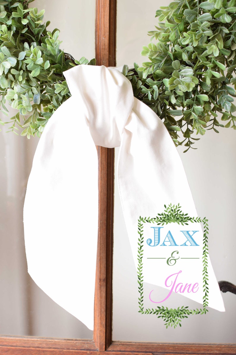 May include: White fabric sash with a green leafy border and the text "Jax & Jane" in blue and pink lettering.