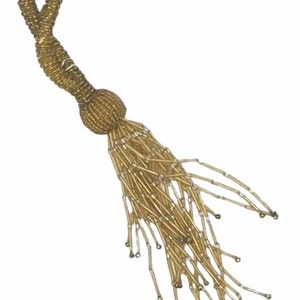 May include: A gold beaded tassel with a long, flowing fringe. The tassel is made of small, round beads that are strung together to create a delicate and elegant look.