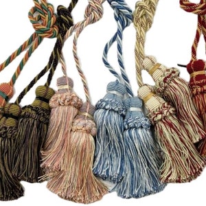 Peut inclure: Ensemble de huit attaches de rideaux à franges de différentes couleurs et motifs, notamment vert, marron, rose, bleu et rouge. Chaque attache de rideau est dotée d'une double frange avec un nœud décoratif en haut.