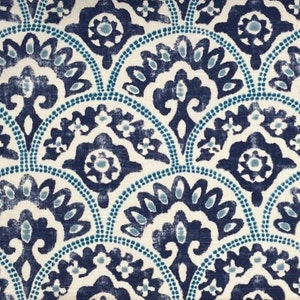 Può includere: Un tessuto con motivo blu navy e turchese con un design ripetitivo di fiori stilizzati e archi. Il tessuto ha un aspetto testurizzato, simile al lino.