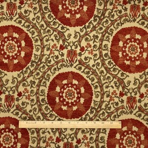 May include: Red, green, and cream patterned fabric with a repeating floral design. The fabric has a textured surface.