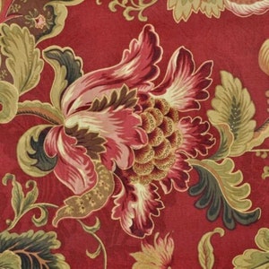 May include: A close-up of a floral fabric with a rich red background. The design features large, stylized flowers in shades of pink, red, and gold, with green and brown leaves. The pattern is intricate and detailed, creating a classic, elegant look.