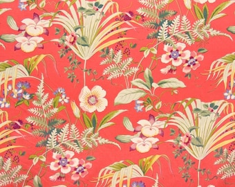 May include: A red floral fabric with a repeating pattern of tropical leaves, flowers, and ferns. The flowers are in shades of pink, white, and yellow.
