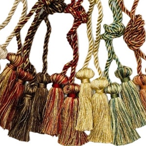 May include: A collection of 10 tassel tiebacks in various colors, including gold, brown, red, and green. The tassels are made of a soft, woven fabric and have a classic, elegant design.