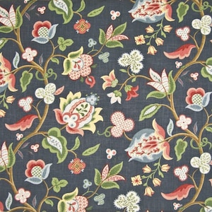 May include: A close-up of a fabric with a dark blue background and a repeating floral pattern. The pattern features stylized flowers in shades of red, pink, yellow, and blue, with green leaves and brown stems. The fabric has a textured appearance.