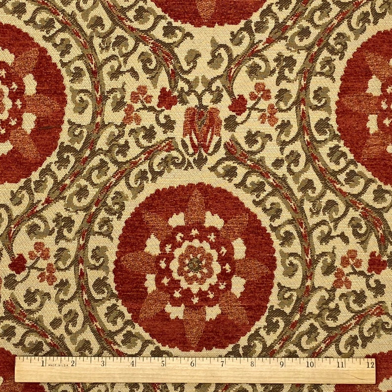 May include: Red and cream fabric with a repeating pattern of stylized flowers and leaves. The fabric has a textured, almost velvet-like appearance.