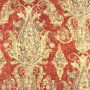 May include: A fabric featuring a repeating damask pattern in shades of metallic gold and dark brown set against a textured, deep rust-red background. The design consists of intricate, symmetrical floral and scrollwork motifs.