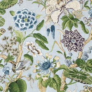 May include: A blue and green floral fabric with a repeating pattern of flowers, leaves, and birds. The fabric has a light blue background and features a variety of floral designs, including peonies, hydrangeas, and roses. The fabric is ideal for upholstery, curtains, or other home decor projects.