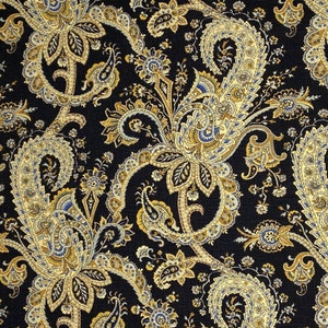 May include: A black fabric with a paisley pattern in gold, cream, and blue. The paisley pattern is intricate and detailed, with a variety of shapes and sizes.