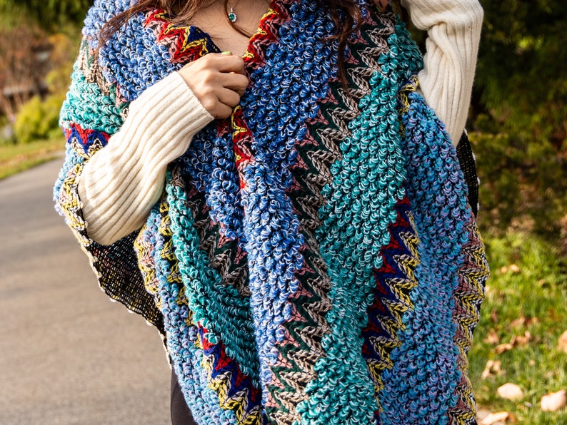 Puede incluir: Un poncho de crochet colorido con un dise&ntilde;o texturizado y abultado. El poncho est&aacute; hecho con una variedad de colores, incluyendo azul, verde, rojo y amarillo.