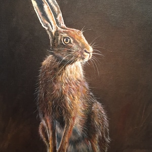 May include: An oil painting of a hare, depicted in a seated pose. The hare's fur is a mix of brown and tan hues, with long, upright ears. The background is a dark brown, which highlights the hare's fur. The artwork captures the animal's alert expression.