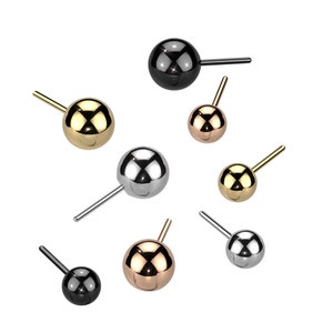 May include: Assortment of six ball stud earrings in various colors, including gold, silver, black, and rose gold. The earrings are made of metal and have a simple, classic design.