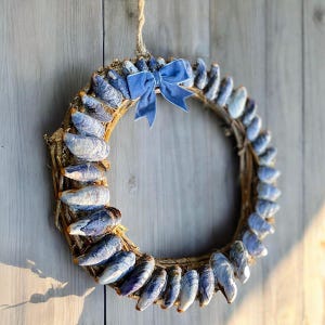 Peut inclure: Une couronne bleue et brune faite de coquillages avec un nœud en velours bleu.