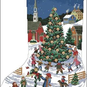 May include: A Christmas stocking featuring a cross-stitch pattern of a winter village scene. A large decorated tree stands in the center with children holding hands around it. A sign labeled ELM ST is visible near a person and a dog.